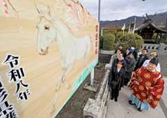 大きな絵馬の仕上がりを満足そうに見上げる東北芸術工科大生ら＝山形市・県護国神社