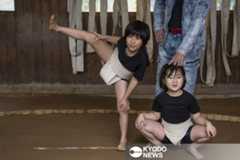 土俵で四股を踏む山岸咲耶さん（左）と妹桃香さん。青木さんの指導の下、週に１回まわしを締める＝２０２５年１１月、石川県珠洲市（共同）