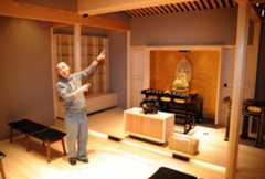 仏像や位牌棚を設けた仏間に立つ吉岡寛順住職（高知市はりまや町１丁目）