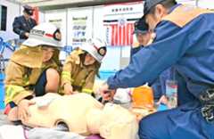 消防士から心肺蘇生の方法を教わる子どもたち=14日、那覇市民体育館