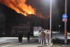 炎を上げて燃える山林＝２３日午後７時９分、岡山市南区飽浦