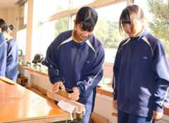 かんなで木材を削って修正鬼会で使う小道具を作る生徒＝豊後高田市松行の戴星学園