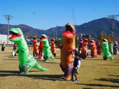 ティラノサウルスの着ぐるみを着て競技を楽しむ家族連れら=11月30日、桜井市三輪の芝運動公園グラウンド