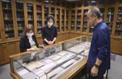 小泉八雲の蔵書を集めた「ヘルン文庫」の展示を見る村上弘美さん（左）と木下晶さん（右）ら＝2025年10月15日、富山市