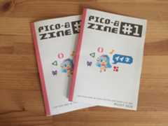 PICO-8 ZINE #1CODE-PLAY-SHARE-BE-THINK-DESTROY-LEARN-BREAK-LOVE-MAKEAUGUST 2015 Two copies of Pico-8 Zine #1 with pixel art character and symbols on white covers, on a wooden surface.