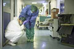 A nurse wearing protective mask and gear comforts another as they change shifts on March 13, 2020 at the Cremona hospital, southeast of Milan, Lombardy, during the country's lockdown aimed at stopping the spread of the COVID-19 (new coronavirus) pandemic. - After weeks of struggle, they're being hailed as heroes. But the Italian healthcare workers are exhausted from their war against the new coronavirus. AFP/Paolo Miranda