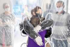 Elisabete Nagata (top) hugs her 76-year-old sister-in-law Luiza Nagata, through a transparent plastic curtain at a senior nursing home in Sao Paulo, Brazil, on June 13, 2020, amid the novel coronavirus (COVID-19) pandemic. AFP/Nelson Almeida 