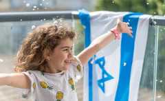 חיבוק מהבית ילדה עם דגל ישראל (צילום: Oren Ravid, shutterstock)