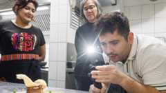 Der Hamburger Food-Influencer Jan-Martin Bauer (jimmy_is_hungryy) testet Schweinebauch in der Bodega Lima auf St. Pauli. Restaurantchefin Monica Orjeda schaut zu.