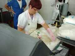 A woman preparing cow intestines to be brined in a salt solution