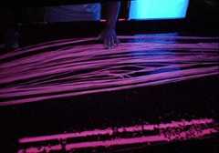 Cow intestine ribbons being inspected under ultraviolet light
