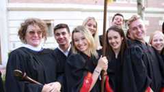 Dawn Stopiello and a group of USC Kaufman students in convocation robes smile for the camera