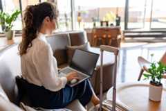 Geschäftsfrau sitzt in edler Flughafenlounge