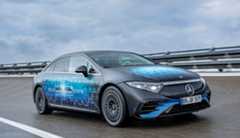 Road test Photo from February 2025 shows a Mercedes-Benz car driving on a race track on a cloudy day. The car is covered with a design showing a charging battery and the words “Solid State.”