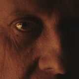 A man's eye appears in the dark.