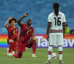 Romelu Lukaku (in centro) e Alex Witsel (a sinistra) del Belgio inginocchiati contro il razzismo prima dell'incontro contro il Portogallo a Seviglia il 27 giugno 2021 (Foto di Thanassis Stavrakis Epa/Ansa)