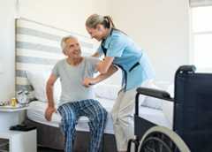 Nurse helping old patient get up