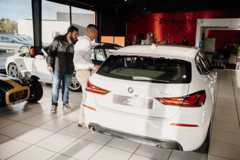 2 hommes entrain de discuter dans une concession automobile