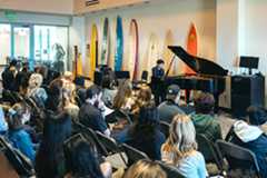 Student performing in front of packed house in the Surfboard Room