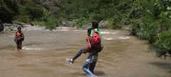 A falta de puente, cruzan rio para llegar a escuela en Padre Las Casas, Azua