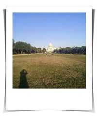 Polaroid photo of the US Capitol in the distance and the shadow of the photographer across the Mall