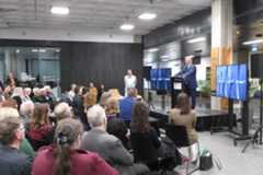 Minister standing at podium in front of crowd at City Gallery Wellington