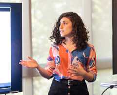 Barbara Alonso Cabrero speaking to a screen on her right: presenting her 2022 Independent Design Engineering Project on social media and civic engagement to her peers.