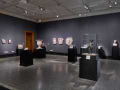 Wide-angle view of a gallery of small sculptures, vessels, busts, and fresco fragments
