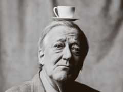 A man balancing a teacup and saucer on his head
