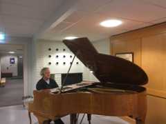 Plagge sitter og spiller på et piano.