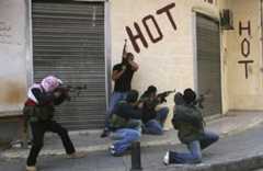 Fire maskerte menn holder hver sin maskinpistol og skyter rundt et hushjørne i gatekamper i Beirut 2008.