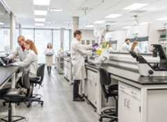 Scientists in white coats working in a lab