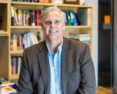 Brian Wirth sitting in his office in front of a book shelf