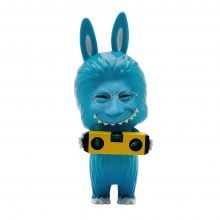 A blue anthropomorphic toy with rabbit ears and a furry body stands holding a yellow level tool. The toy has a digitally altered human face with glasses and a wide grin, giving it a surreal and humorous appearance.