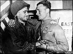 American GI greeting Russian soldier with handshake and arms round shoulders