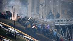 Protesters climb the side of a bridge