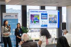 Students standing next to a screen make their pitch for ReMove to judges at the Berkeley Civic Innovation challenge.