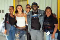 group of Black students and adults smiling and wearing denim and Cal gear