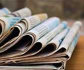 Stack of newspapers on wooden table