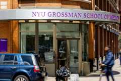 N.Y.U. Grossman School of Medicine building. It is a red brick building. People are walking outside the building and a large sign with “NYU Grossman School of Medicine'' is in the front.