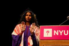 A Film and Television student receiving their symbolic diploma silently protests by raising their hands to reveal “NO JUSTICE” and “NO PEACE." (Julia Smerling for WSN)