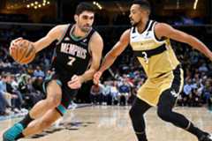 Santi Aldama intenta entrar a canasta ante la defensa de CJ McCollum.