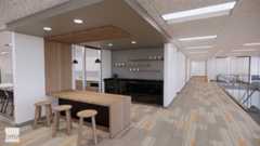 A small kitchen area with counter and three barstools