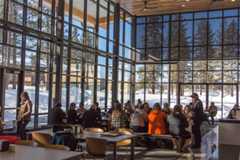 students sitting together at a table surrounded by windows