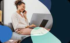 A person is sitting on a couch working on a laptop.