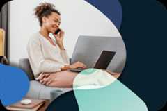 A person is sitting on a couch working on a laptop.