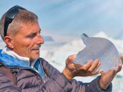 Scientist examining small iceberg in Jokulsarlon Glacier Lagoon