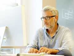 Smart casual businessman working with headphones in modern office