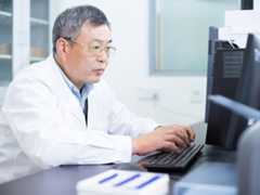 Asian older man analysises chemical experimental data in computer in lab