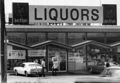 a black and white photograph of the Four Winds liquor store on Admiral Wilson Boulevard